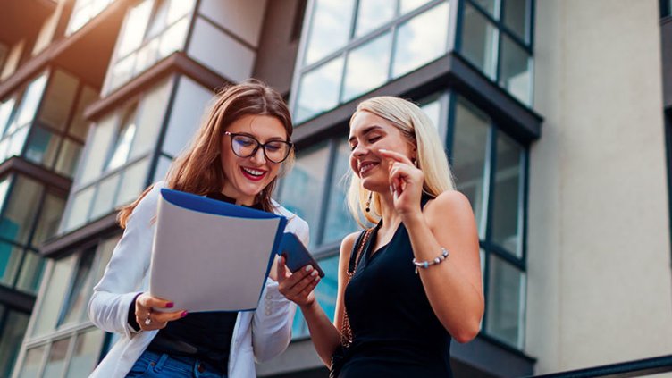 Two women looking at the paper