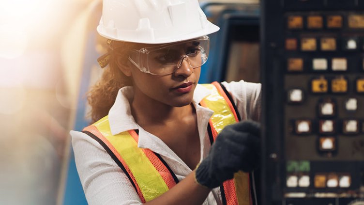 African-American female engineer performing quality control inspection in a manufacturing plant