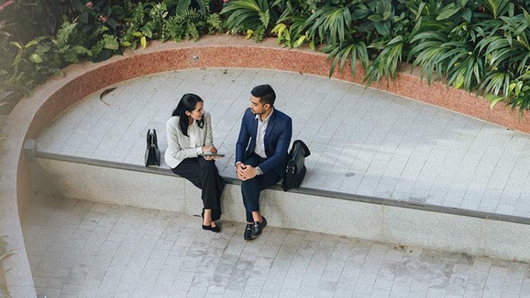 Coworkers discuss sustainability practices outside office