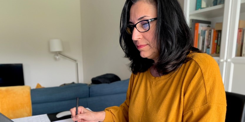 Businesswoman taking notes during a meeting in her office.