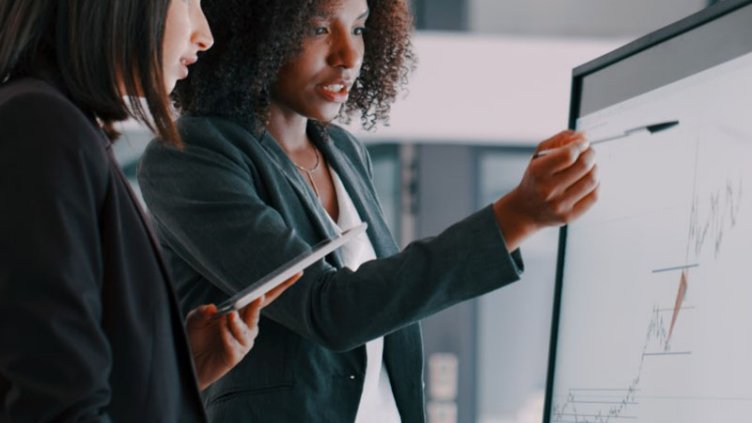 Two women looking at analytics on a computer screen