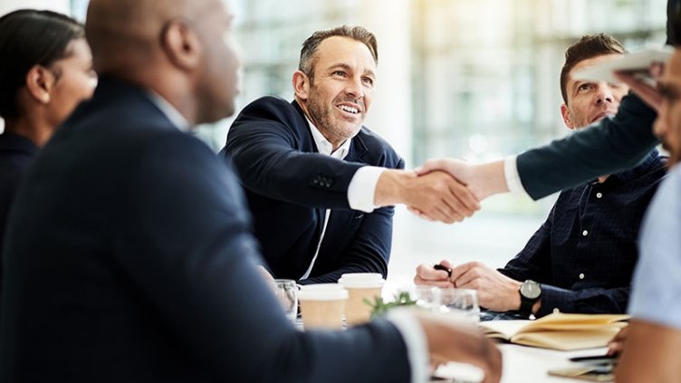 Shot of businesspeople shaking hands during a meeting in an office