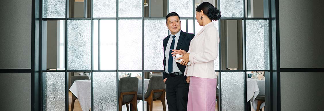 Asian Chinese CEO is talking to secretary on corridor in a hotel