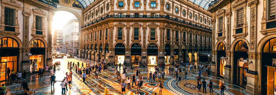 People in a luxury shopping mall in Milan at sunset.
