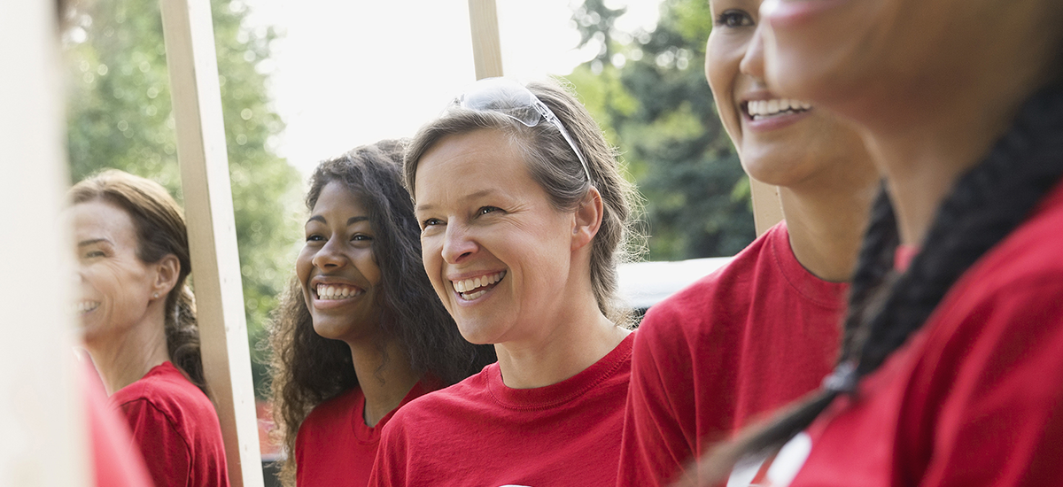 Smiling volunteers at construction frame