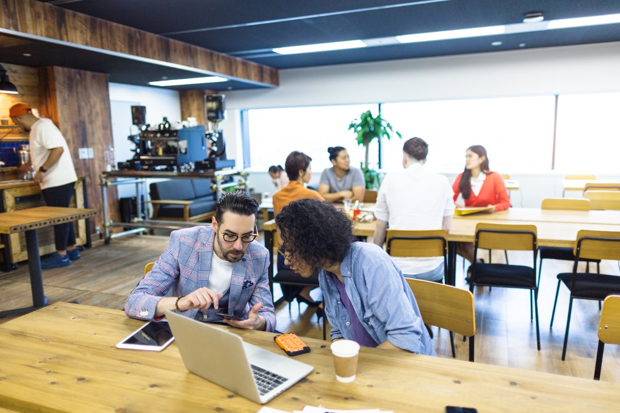 Multi-ethnic people are working together in a modern co-working space.